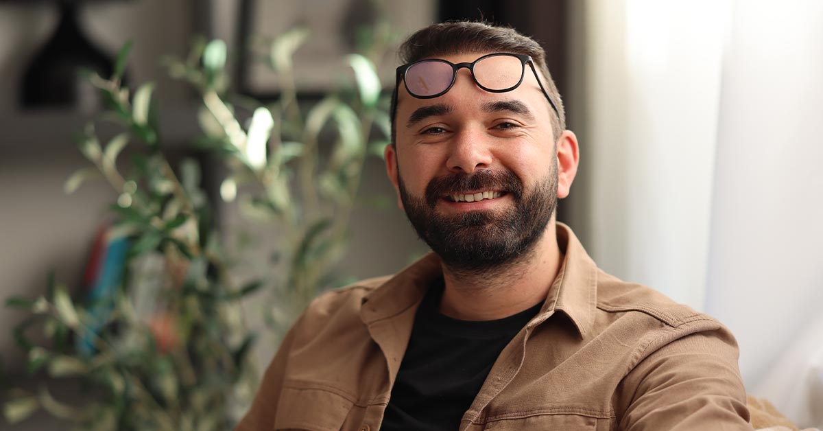 A smiling man with glasses and a beard.