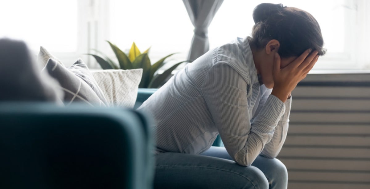 woman sitting on couch thinking about problem or having depression