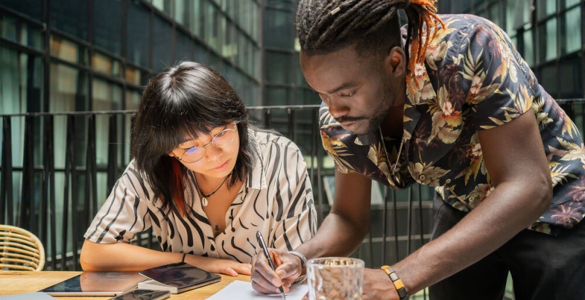 University students writing down their ideas on paper