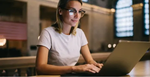 Student working on laptop with glasses