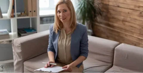 Counsellor holding clipboard in professional setting