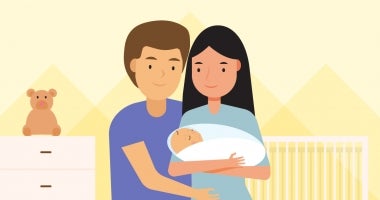 A mother and father hold a newborn baby.